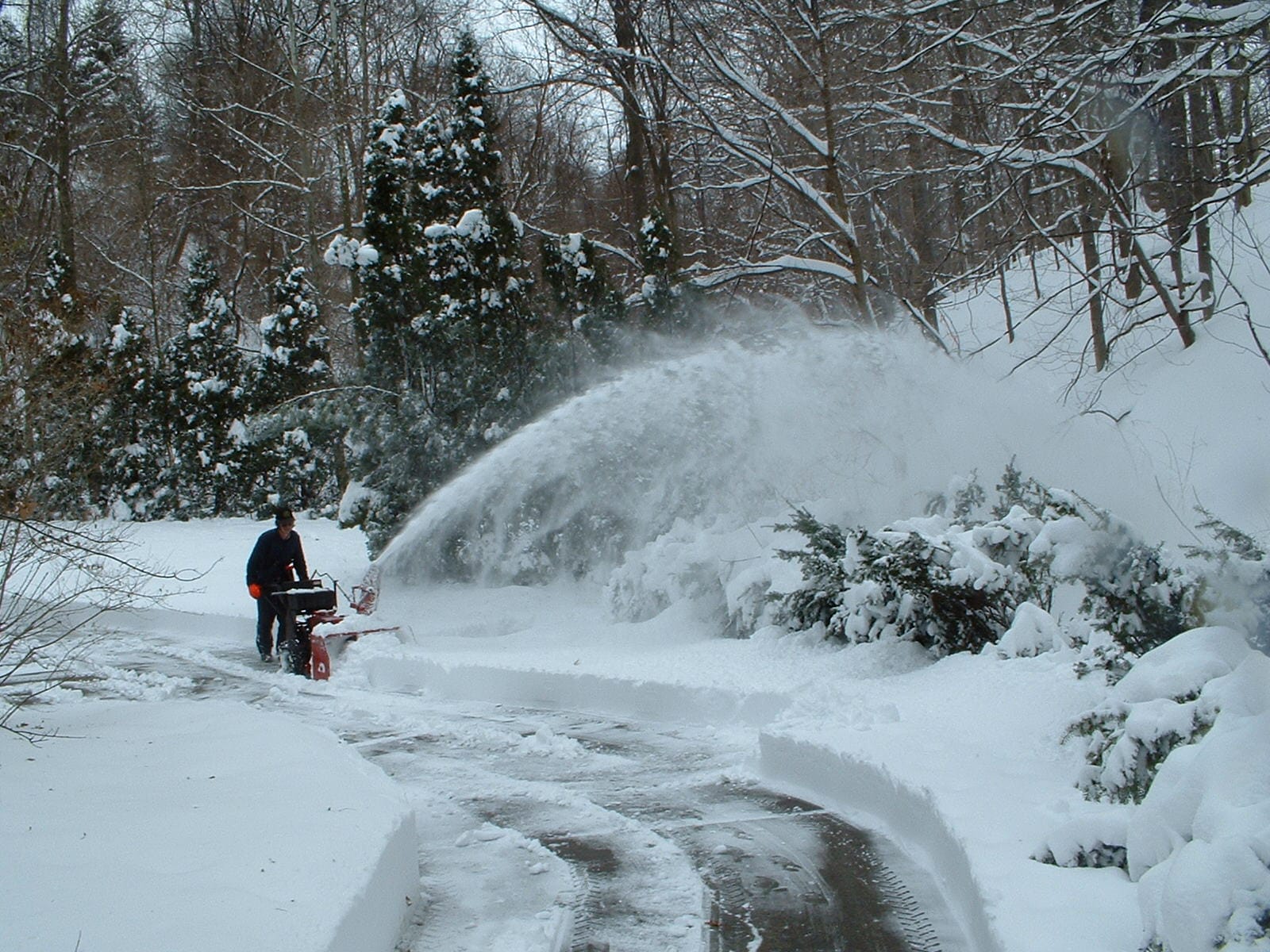 Souffleuse à neige dégageant une entrée résidentielle en hiver